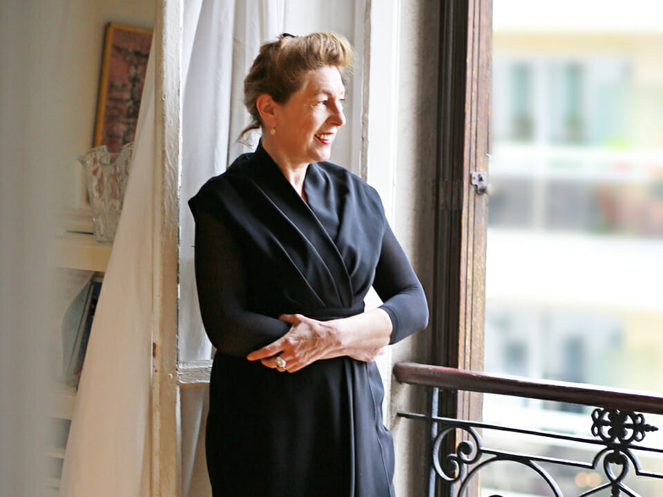 La conteuse Jeanne Ferron pose debout devant une fenêtre.